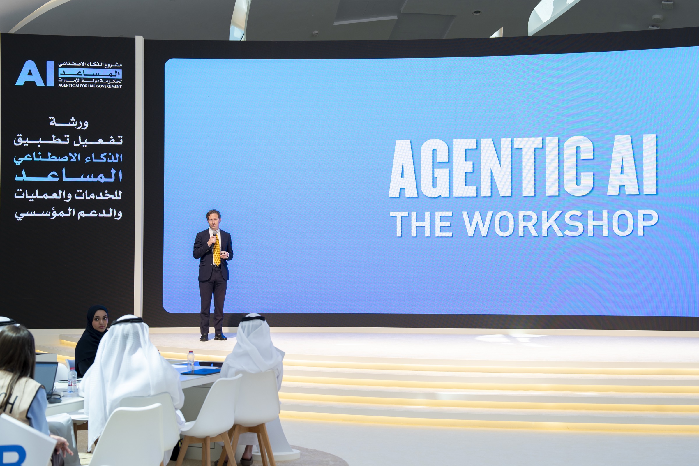 Manuel Kilian presenting on stage at the Agentic AI workshop for the UAE Government in Dubai, with a screen reading 'Agentic AI: The Workshop' behind him